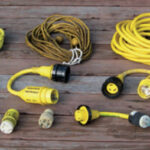 The contents of a typical shorepower bag, from left to right. Top row: cable-TV cord, telephone cord, 30A 125VAC power cord. Middle row: 30A 125VAC to 15A 125VAC adapter, 50A 125VAC to 30A 125VAC adapter, 50A 250/125VAC to 30A 125VAC adapter. Bottom row: polarity checker, 15A 125VAC to 30A 125VAC adapter, 30A 125VAC to 15A 125VAC adapter, 20A 125VAC to 30A 125VAC adapter. It’s a good idea to label the adapter with not only the type of socket it fits, but also with the name of your boat, so that on a marina dock there’s no question about who owns the adapter.