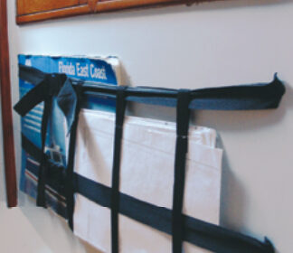 Charts accumulate in great numbers on a cruising boat and storing them flat often presents a challenge. Connie turned the problem on its side and attached a “chart basket” to a bulkhead.