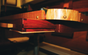 Joe fitted two shallow drawers beneath the tabletop. Runners attached to the sides of the drawers slide in grooved cleats fastened to the table. The fiddles are held by brass bolts screwed into threaded inserts in the table edge.