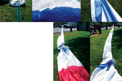 A borrowed lawn and a calm day provide the ideal setting for socking a spinnaker. Lay out the sock and the spinnaker, concertina the sock, and attach the head of the folded spinnaker inside the head of the sock. Pull the sock ring to enshroud the sail, then stuff the sock into the bag so the head and clews go in last.