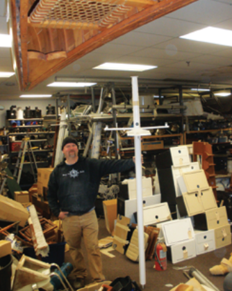Billy Leach, manager of the Marine Consignment of Mystic store in Mystic, Connecticut, shows up from time to time to help out in the Wickford, Rhode Island, store. His job at the moment seems to be as stabilizer for a short mast.