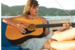 A woman playing guitar on a boat