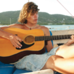 A woman playing guitar on a boat