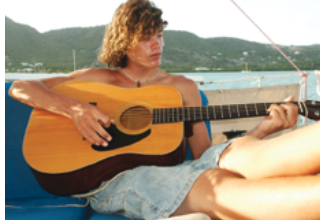 A woman playing guitar on a boat