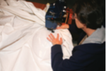 Someone sewing a sail