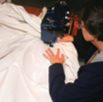 Someone sewing a sail