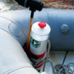 A length of PVC pipe contains the dinghy anchor and displays the decals required by law.