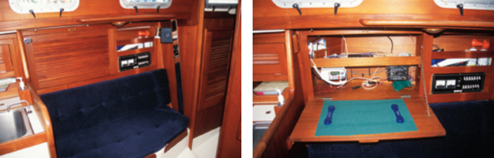 The port-side saloon settee is short, to allow room for the galley. Above the settee, the outboard locker door swings down to become a chart table. The fiddled shelf holds the navigator’s tools and John Ollila has installed a VHF radio in the locker. The switch panel is forward of this nav center.