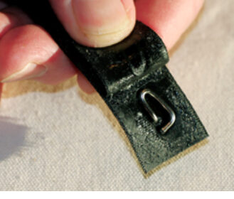 A simple turnbuckle lock can be made from a short length of wire and sticky-back Velcro, at top. The pin end of the wire pokes through the “hooked” Velcro and the loop holds it in position, at center. When the “fuzzy” Velcro is applied, the loop is held fast, at bottom. The combined Velcro strip sticks to itself when wrapped around the turnbuckle, holding the pin in the screw.