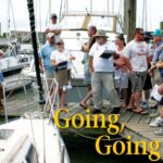 Holding clipboards, auctioneers Cheryl Tucker, Watergate Yachting Center’s general manager, and Tony Buchanan, harbormaster, encourage bidding on a 1983 S2 7.3.