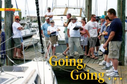 Holding clipboards, auctioneers Cheryl Tucker, Watergate Yachting Center’s general manager, and Tony Buchanan, harbormaster, encourage bidding on a 1983 S2 7.3.