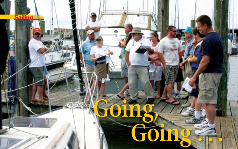 Holding clipboards, auctioneers Cheryl Tucker, Watergate Yachting Center’s general manager, and Tony Buchanan, harbormaster, encourage bidding on a 1983 S2 7.3.