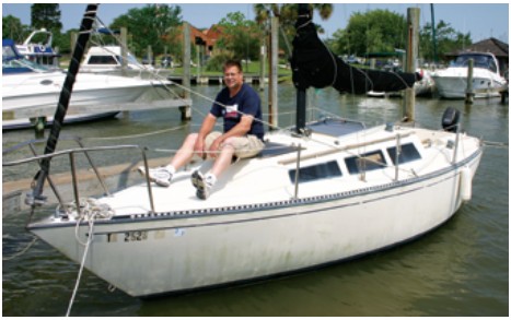 Chuck Vastine enjoys a few moments aboard his new boat. His winning bid for the S2 was $1,500, the top price paid for a sailboat at the auction.