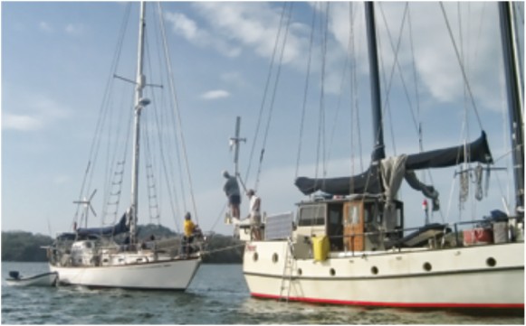 A team of helpers, assembled from cruising boats in a remote anchorage in Panama, watches as Philip prepares to lower Carina’s forestay onto the deck of the schooner RDreamz.