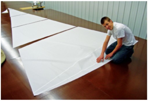 The “bubbles” in these basted seams are the result of the curved panel edges. When the sail is filled with air, they will give it its proper shape.