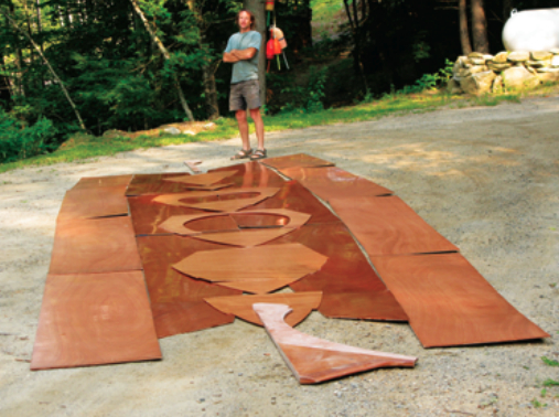 All the plywood parts for one hull, some already saturated with epoxy, await assembly.
