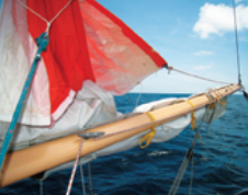 The clew outhaul stays rigged through its cheek block on the boom, always ready for action.