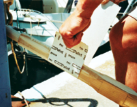 Sanding across the grain is an effective way to smooth a round object like an oar.