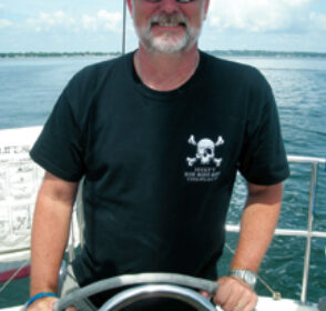 Picture of a man at a boat helm