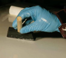 Tipping the paint by lightly dragging a paintbrush to break bubbles and smooth the pattern left by the roller.