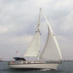 Solitude, a 1988 Aloha 32, is sailed by Wes and Sally Orloff, at left. Lake Erie’s Fairport Harbor Light is in the background.