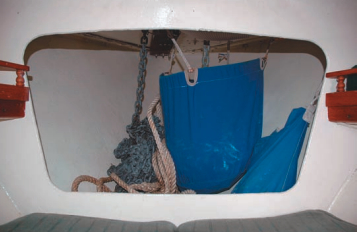 The V-berth is open to the forepeak, where anchor rodes are stowed. With two anchors on Catspaw’s bow, the canvas bag holds one rode separate to prevent tangles. Cleaning the rode on deck reduces odors below.