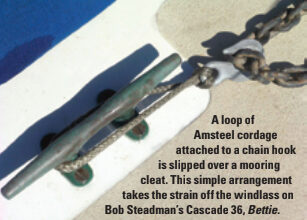 A loop of Amsteel cordage attached to a chain hook is slipped over a mooring cleat. This simple arrangement takes the strain off the windlass on Bob Steadman’s Cascade 36, Bettie.