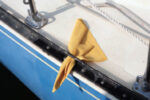 A square of faux chamois tucked through a toerail perforation wicks away the annoying puddle of water that tends to linger at the low point in the deck, leaving muddy reminders of anchorages past as it evaporates.