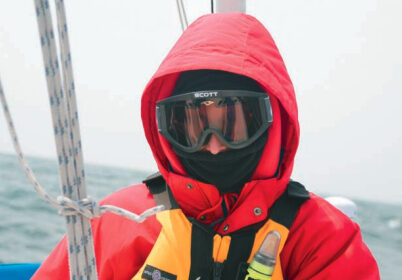 A picture of someone bundled up from the cold on a boat