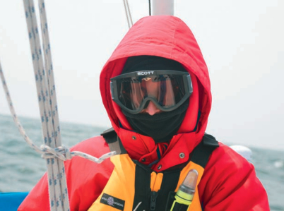 A picture of someone bundled up from the cold on a boat