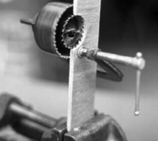 One clever way to enlarge a hole — without having an existing center for your hole saw — is the saw-within-a-saw trick, illustrated here in cutaway view.