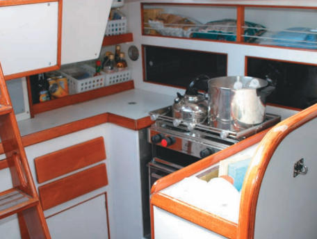 The U-shaped galley in the port quarter has the essentials: refrigerator, sink, and propane stove/oven.