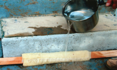 Paul wrapped a towel around the three boards to be used in the lamination and poured hot water over them. After soaking for about 20 minutes, they were pliable enough to conform to the laminating jig without cracking.