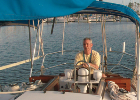 Gary mans the wheel as he and Sheryl head out for an afternoon sail on a balmy February afternoon. The beads around his neck were acquired earlier in the day during a Mardi Gras parade.