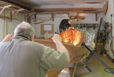 Hilford and Brahm aligning thwart risers on a Newfoundland trap skiff from the designs of W.J. Simmons of Duck Trap Woodworking.
