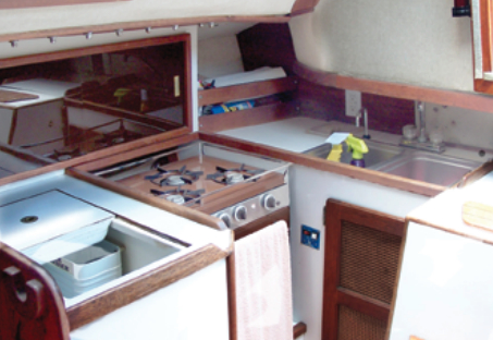 The galley is aft to starboard, with a double sink under the bridge deck, a three-burner gimbaled stove/oven, and icebox. There isn’t much counter space.