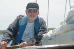 Picture of a man leaning on a boat
