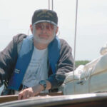 Picture of a man leaning on a boat