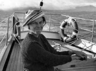 Margaret wears a marvelous Cheshire grin along with her tam-o’-shanter while sailing Golden Feather.