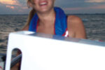 Jyllian at the helm in 2005. The white object in the foreground is Michael’s homemade nav station.