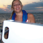 Jyllian at the helm in 2005. The white object in the foreground is Michael’s homemade nav station.