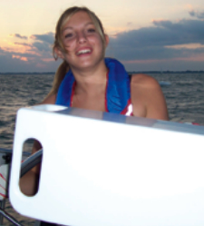 Jyllian at the helm in 2005. The white object in the foreground is Michael’s homemade nav station.
