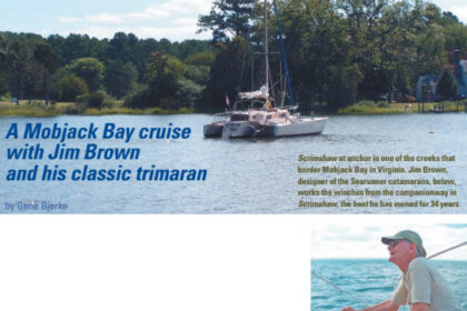 Scrimshaw at anchor in one of the creeks that border Mobjack Bay in Virginia. Jim Brown, designer of the Searunner catamarans, below, works the winches from the companionway in Scrimshaw, the boat he has owned for 34 years.