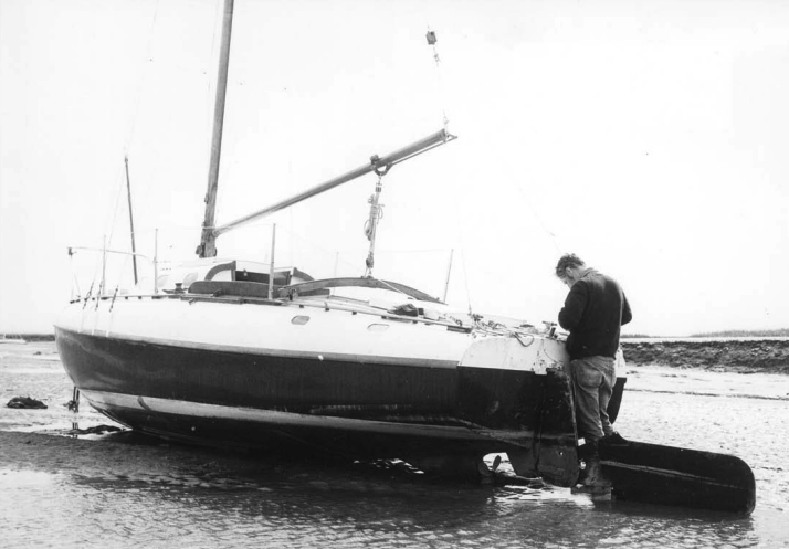 Richard Smith and Jane Duck, his Fairey Atalanta 26, on Heswall mud, waiting for enough water to lift them into the Irish Sea.