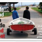 two people pulling a boat on a trailer