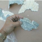 A section of cracked gelcoat that was scraped off the hull shows the white fiberglass mat with little resin, probably poorly wetted out in the manufacturing process. The gelcoat thickness is also a factor. Here, the thickness is about 1⁄8 inch.