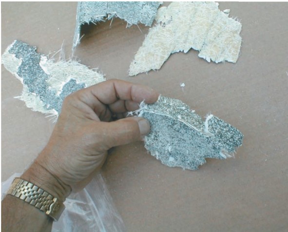 A section of cracked gelcoat that was scraped off the hull shows the white fiberglass mat with little resin, probably poorly wetted out in the manufacturing process. The gelcoat thickness is also a factor. Here, the thickness is about 1⁄8 inch.