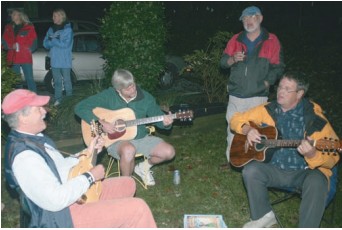 The musicians play their own Good Old Boat song. From left, Alfred Poor, Geoff Swanhart, Jerry Powlas (playing a glass of wine only), and Tom Wells, the composer of good old tunes.