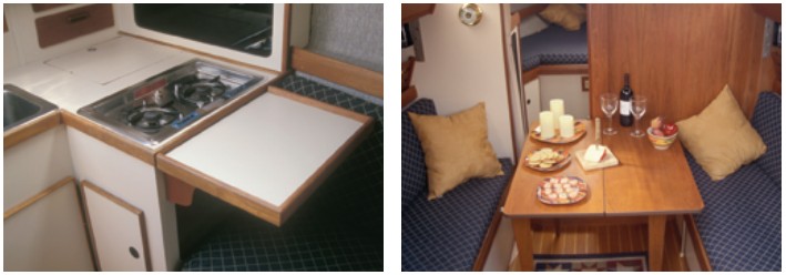 The galley is compact, to be sure; the icebox is poorly insulated. A flip-up counter extension increases space for food preparation, at left. The dinette table folds down from the main bulkhead and comfortably seats four, at right.
