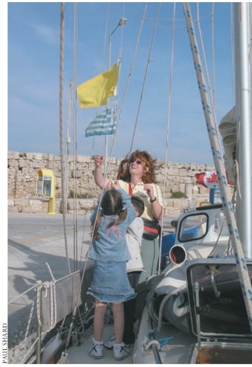 Sheryl Shard shows a few children in Rhodes a few things about flag etiquette after clearing into Greece.